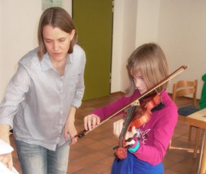 Kinder lernen die ersten Grundlagen auf der Geige.